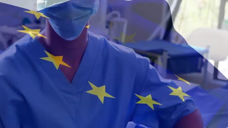 Animation-of-flag-of-european-union-over-caucasian-female-surgeon-in-face-mask