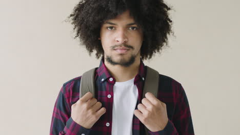 portrait of young mixed race man with afro standing serious student