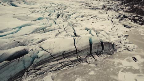 Glacier-tongue-in-Iceland-filmed-by-drone-with-different-cinematic-movements,-showing-a-cloudy,-dramatic-concept-in-wintery-conditions