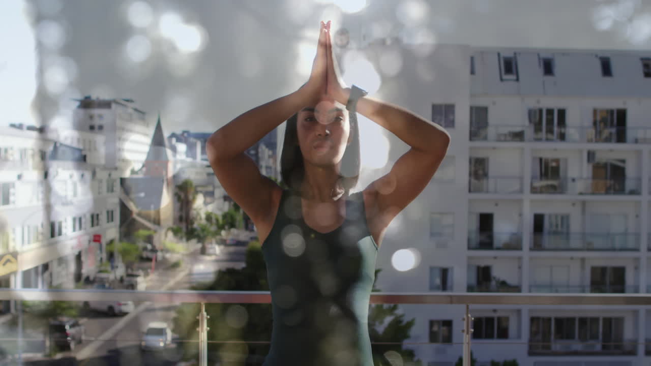 animación de luces brillantes sobre una mujer biracial practicando yoga