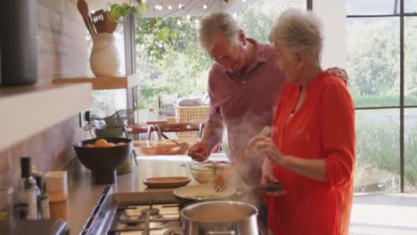 pareja caucásica de alto nivel cocinando juntos en la cocina