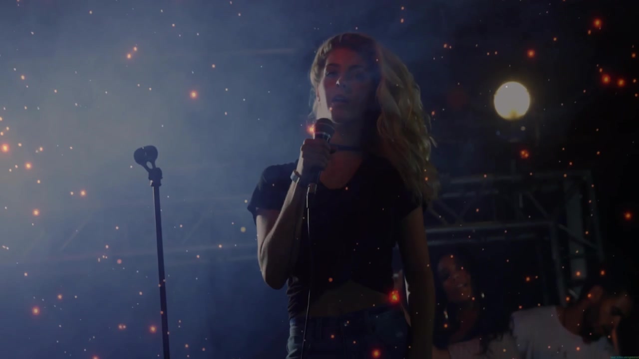 Lead singer whipping hair at music concert, sparking ember overlay, band playing, singing into mic