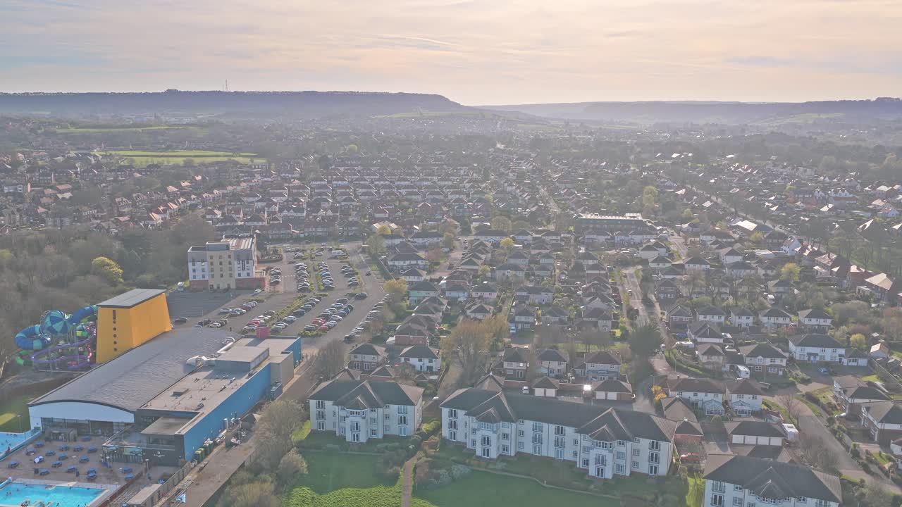 Alpamare Scarborough, situato su Burniston Road nel distretto di Newby, mostra un complesso ricreativo con piscine e scivoli adiacente a quartieri residenziali, ripresa in discesa con drone.