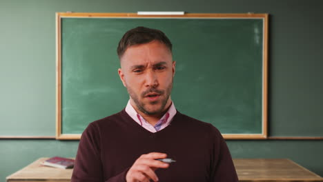 close up shot of mature male teacher in classroom standing in front of board teaching lesson 1