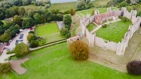 aerial: framlingham castle with car parking lot at suffolk, england - drone tracking shot