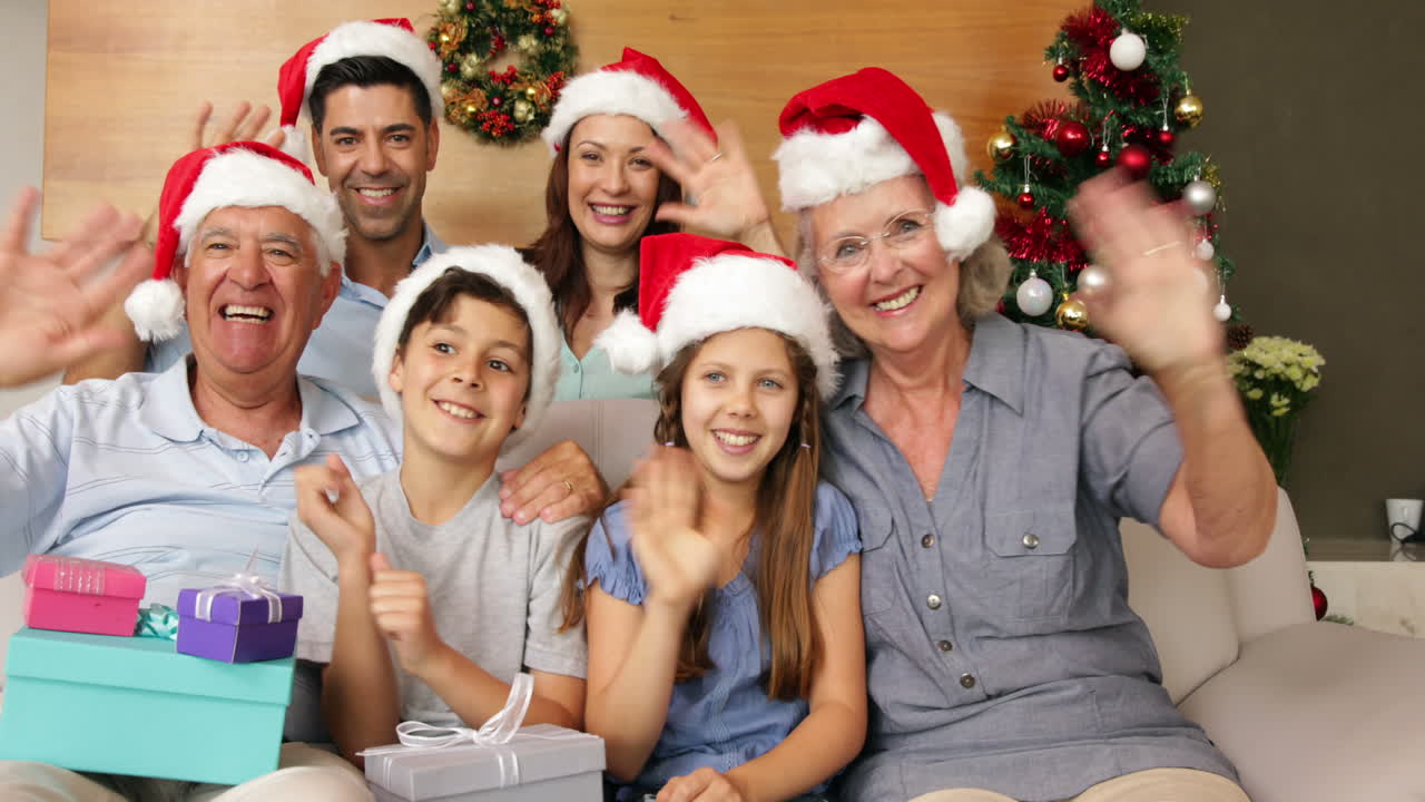 Familia extendida feliz saludando a la cámara en Navidad
