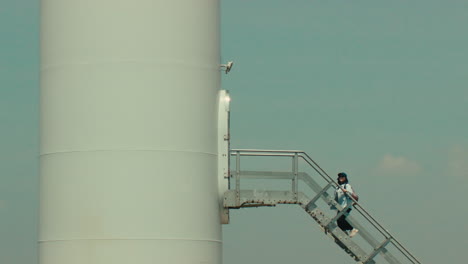 Woman Climbing Wind Turbine Tower