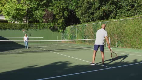 Afroamerikanisches-älteres-Paar,-Das-An-Einem-Strahlend-Sonnigen-Tag-Tennis-Auf-Dem-Tennisplatz-Spielt