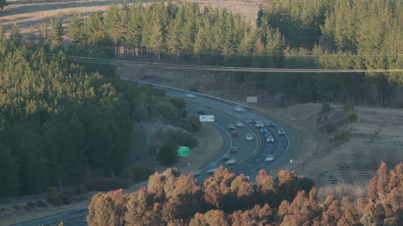 Vehicles blur across the highway at sunrise, capturing the fast pace of Canberra’s daily commute in glowing morning light