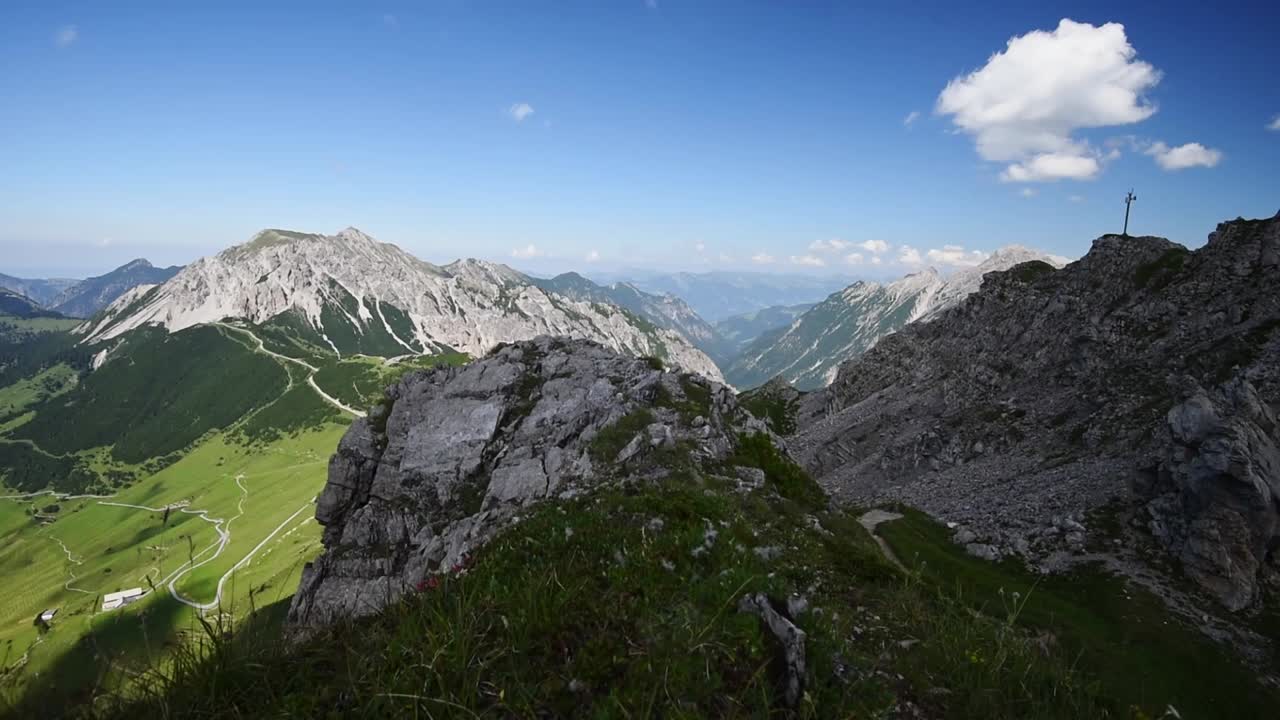Wide angle pan left over the mountain top offering a panoramic view of the alps at the border of Austria and Liechtenstein