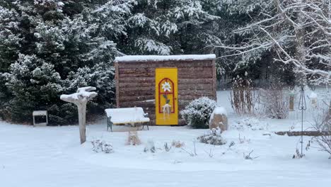 calm and tranquil winter snowfall scene with fresh snow covering country forest and birds at feeders in slow motion