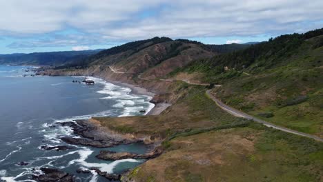 4k 30fps aerial footage oregon coast - static shot of us route highway 101 - ocean waves crash against oceanside rock formations as people road trip down the pnw coast - epic nature landscape