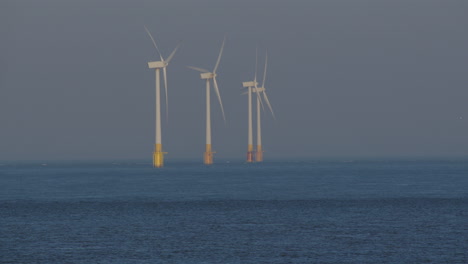 long shot of 3 offshore wind turbines at scroby sands wind farm