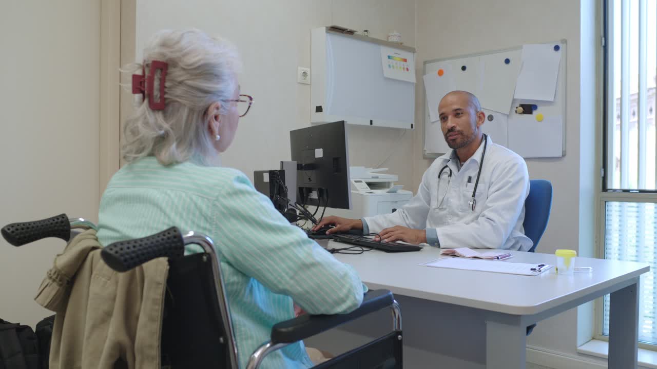 Doctor consulting with elderly patient in wheelchair