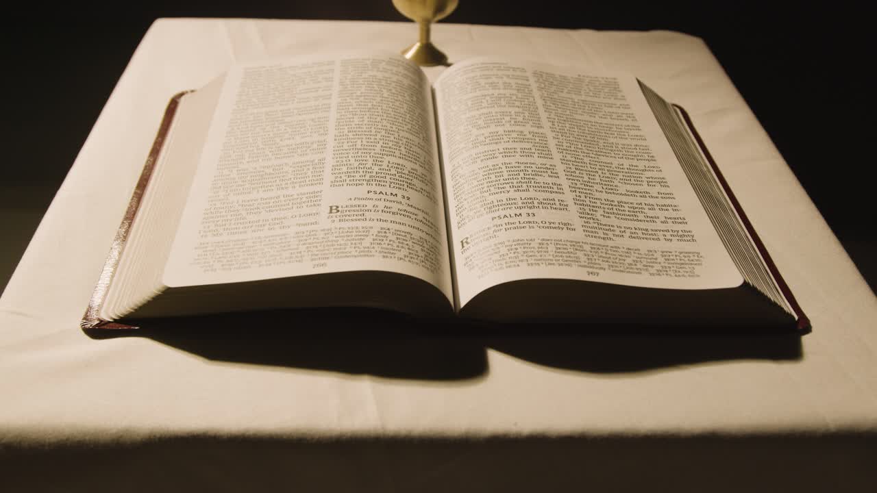 Religious Concept Shot With Open Bible And Chalice On Altar In Pool Of Light 1
