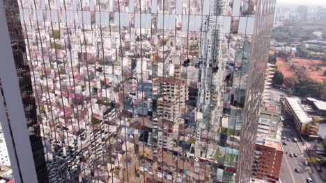 aerial track shot showing group of industrial window cleaner,washing mirrored skyscraper during sunny day - maintenance worker in high altitude