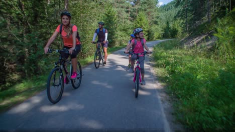 caucasian lifestyle family ride bikes at park in slovenia, slow motion