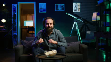 ecstatic man watching sports broadcast at home, doing frantic hand gesturing