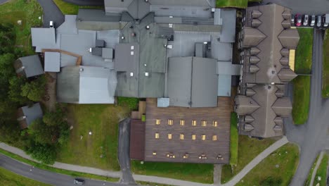 Rooftop-and-surroundings-at-Vestlia-resort-and-hotel---Forward-moving-top-down-aerial-showing-roof-beside-parking-lot-and-water-slide---Norway