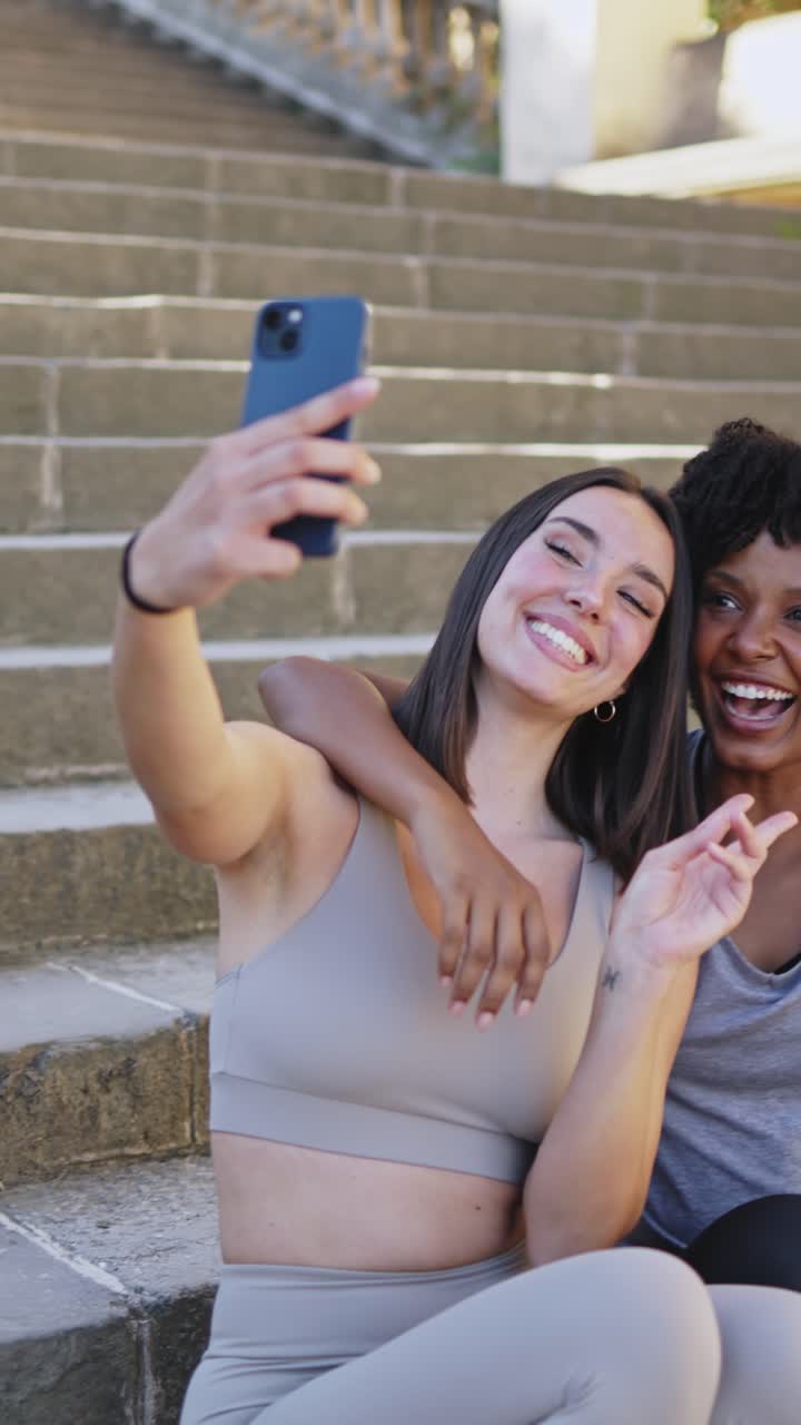 Giovani donne diverse che si scattano selfie e ridono all'aperto