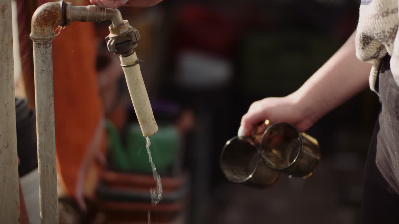 수도꼭지에서 물로 안경을 씻는 여성의 핸드헬드 샷