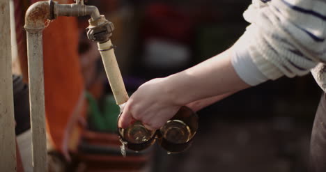 Handheld-Shot-Of-Woman-Washing-Glasses-With-Water-At-Faucet