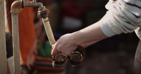 toma de mano de una mujer lavando vasos con agua en el grifo