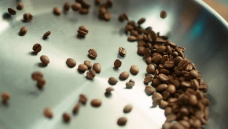 closeup coffee seeds roasting on pan in slow motion. roasted coffee beans.