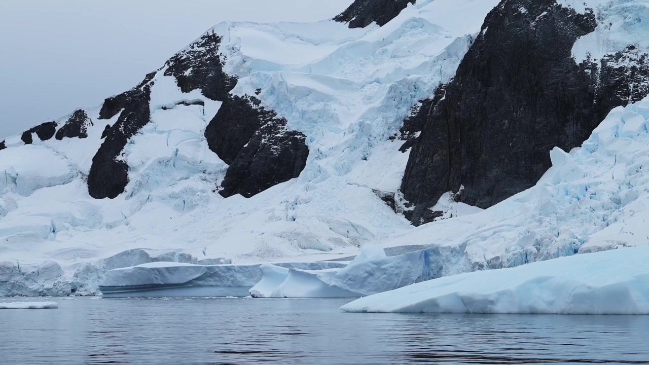 Antarctica Winter Iceberg Landscape on Coast in Cold Blue Antarctic Peninsula Scenery with Mountains and Snowy Snow, Ice and Glacier in Dramatic Beautiful Coastal Scene with Ocean Sea Water