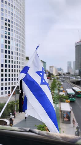 flag of israel on the background of modern city.