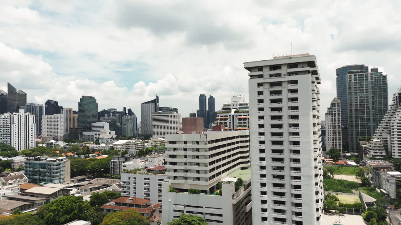 Modern Cityscape Of Chiang Mai, Thailand With High-rise Buildings And Rooftop Pool. aerial tilt-down shot