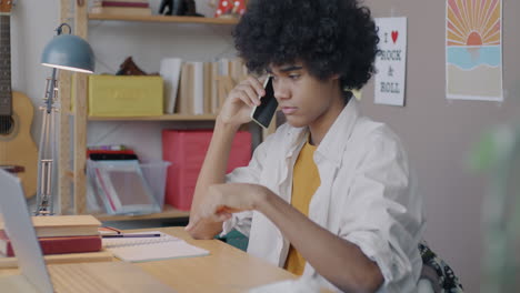 teenager talking on phone while studying