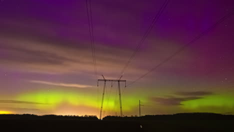 purple and yellow northern lights over transmission tower