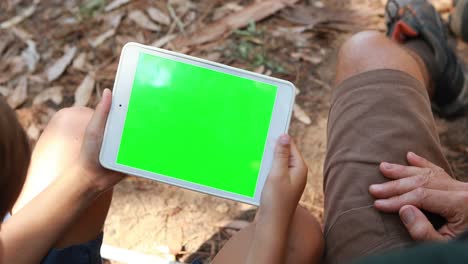 padre e hijo usando tableta digital fuera de la tienda