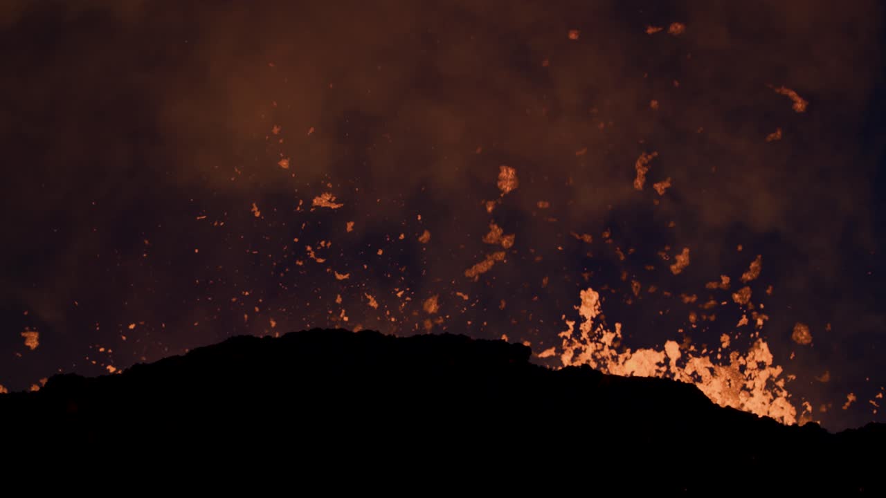 Hot glowing lava shoots high in the air during volatile volcano eruption