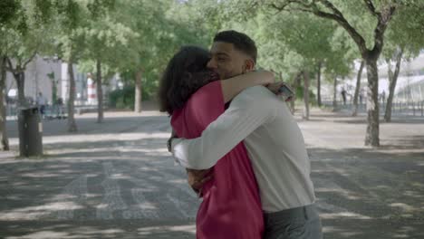 happy couple reading good news and hugging in park