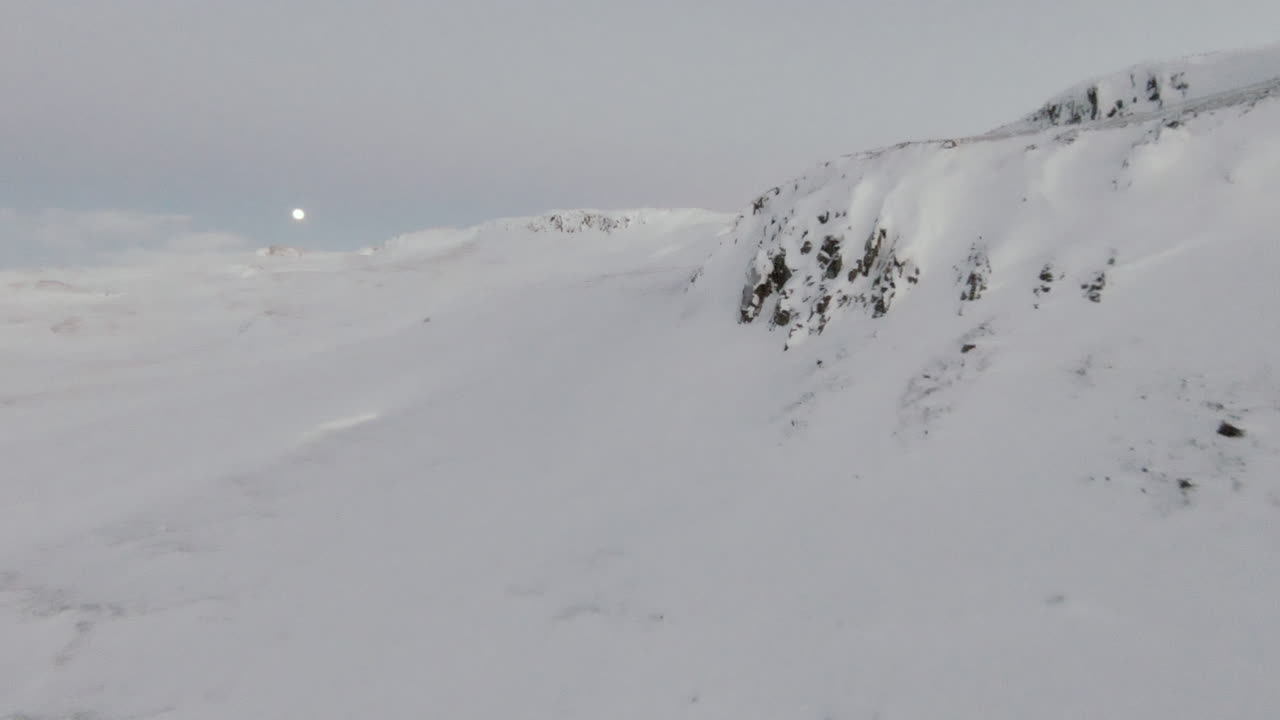 заснеженные изрезанные горы с полной луной на пастельно-голубом небе, куколка вперед