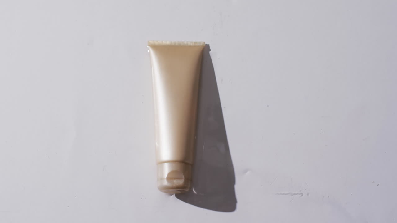 Video di un tubetto di prodotto di bellezza in acqua con spazio per il testo su sfondo bianco.