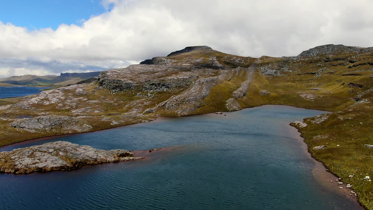 라구나스 데 알토 페루(lagunas de alto peru)의 녹색 초원과 울퉁불퉁한 지형 속에 있는 석호의 깨끗한 푸른 물