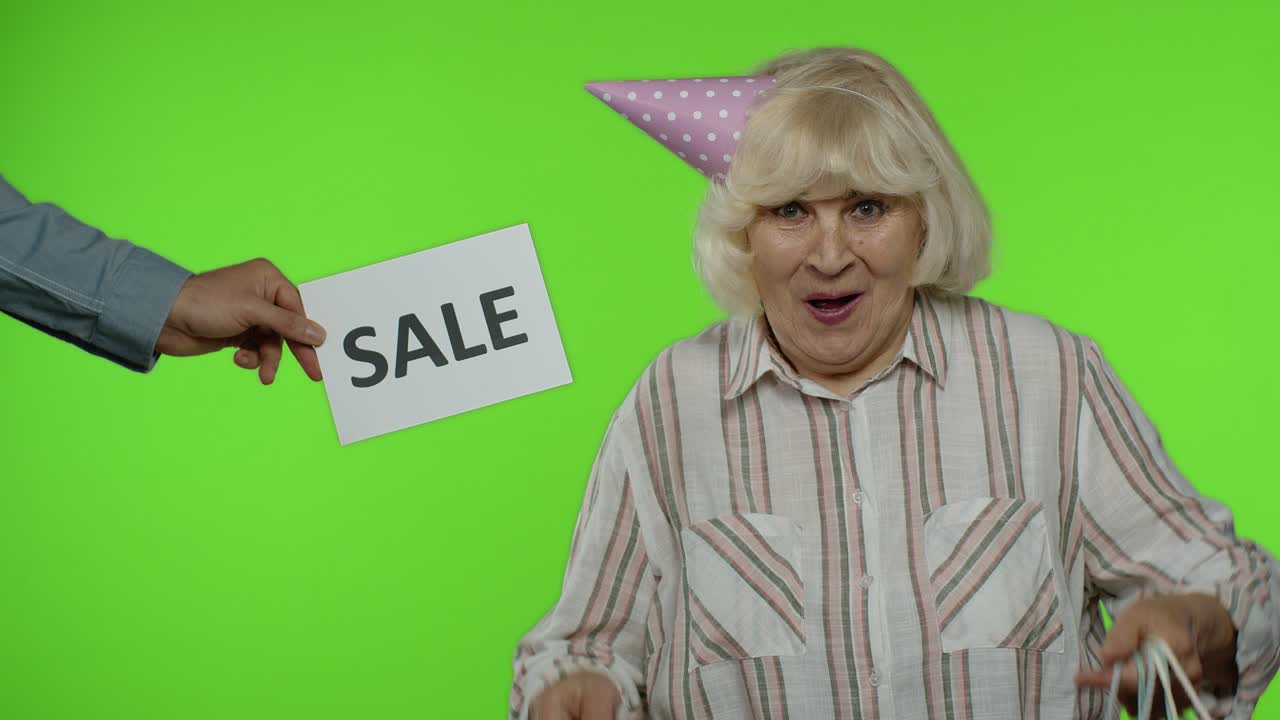 쇼핑 가방을 가진 기쁜 할머니 에 광고 판매 단어가 나타납니다.