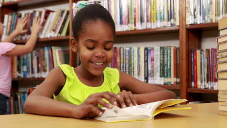 una niña sonriente leyendo un libro