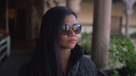 mujer asiática con gafas de sol durante el invierno apreciando la vista del templo sagrado de qorikancha en cusco, perú