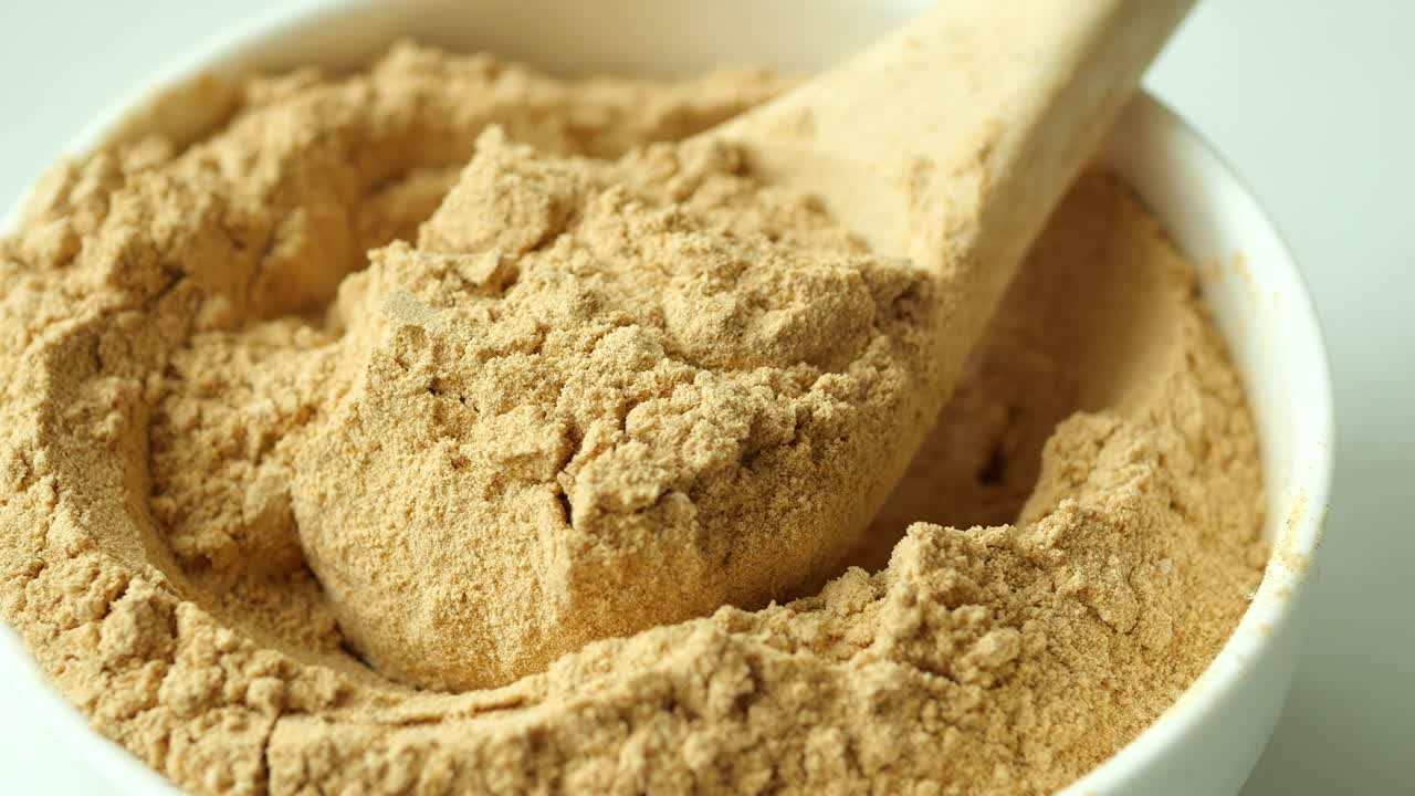 Brown Powder in a Bowl with Wooden Spoon