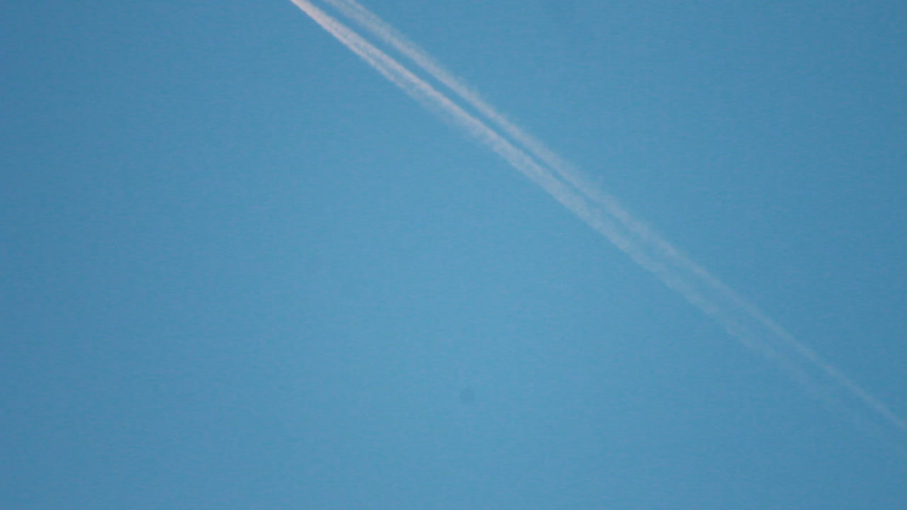 푸른 하늘을 가로지르는 비행기