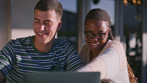 two people looking at a laptop