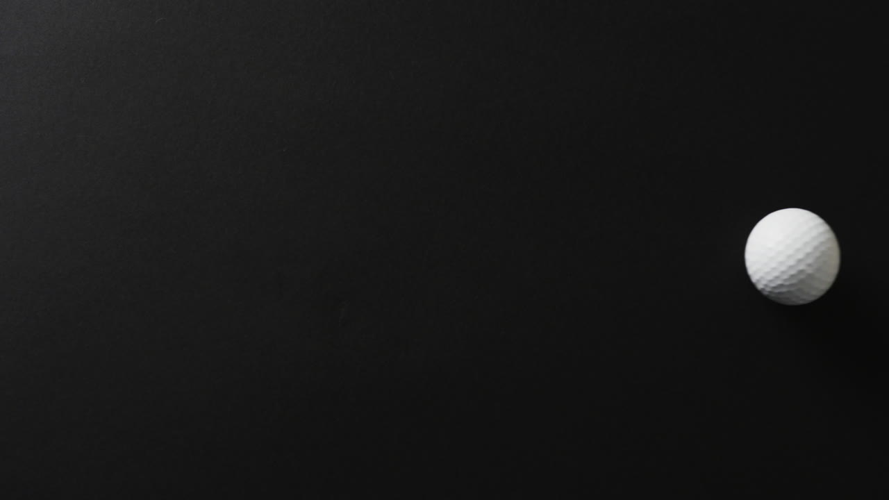 검은 바탕에 있는 골프 공의 클로즈업, 복사 공간, 슬로우 모션