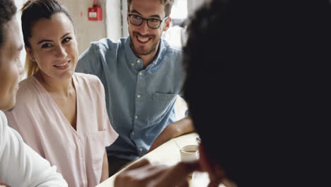 Woman-showing-engagment-ring-to-friends-in-cafe-celebrating