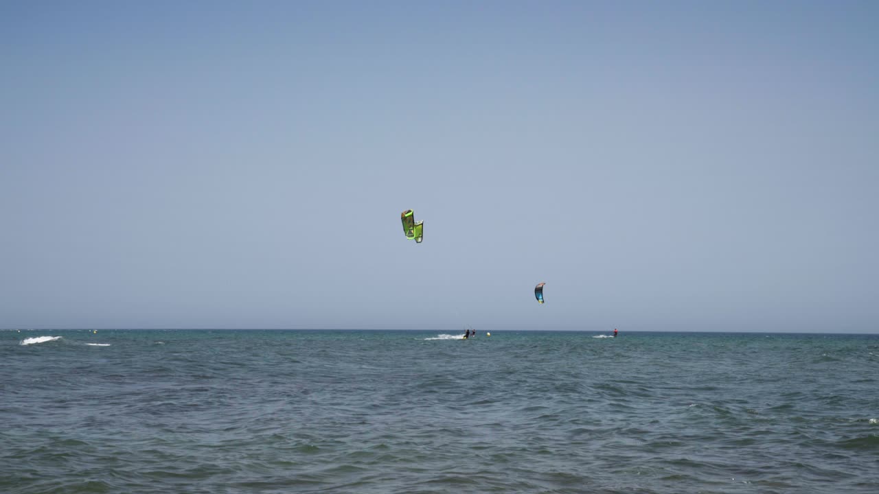 Along the coast of Cala De Mijas on the Costa Del Sol three kite Surfers sail along together