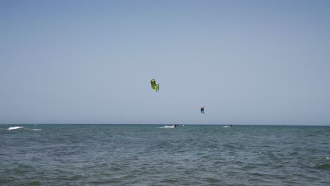 along the coast of cala de mijas on the costa del sol three kite surfers sail along together