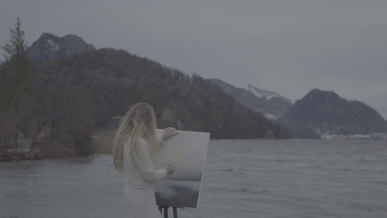 Woman Painting a Landscape by the Lake in Winter